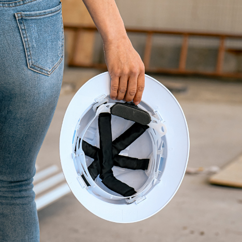 Worker walking and holding a hard hat with a fitted Ruff Supplied sweatband in their hand