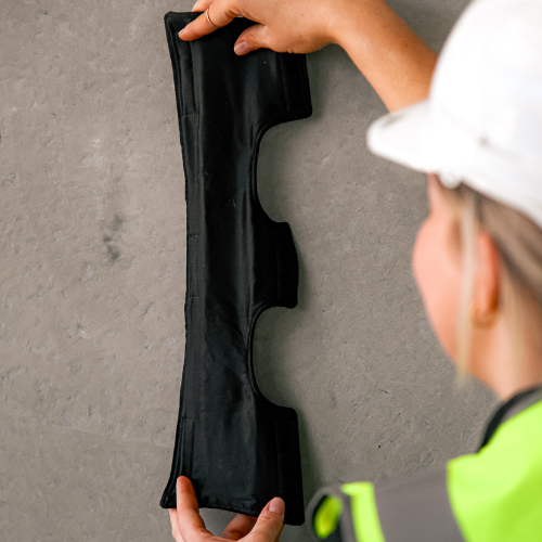 Hard hat worker stretching a Ruff Supplied sweatband on the wall