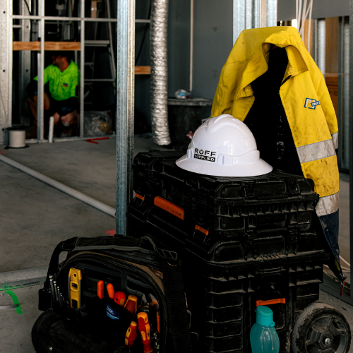 Ruff Supplied hard hat sitting on a set of tool boxes with a high vis vest hanging on the side